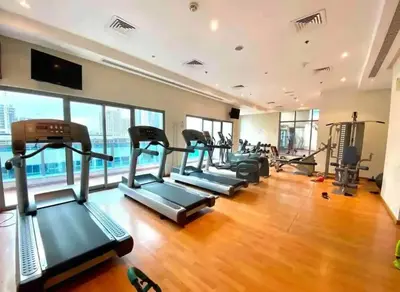 a gym with a row of treadmills and ellipticals at One Bedroom Apt in Dubai Marina near beach Z1911 in Dubai