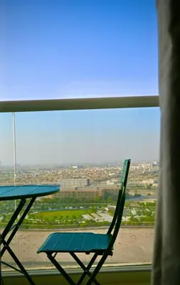 a table and a chair in front of a window at Fully Furnished Elegant Studio Apartment Close by Dubai Science Park, Dubai Miracle Garden, Butterfly Garden and Dubai Hills Mall in Dubai