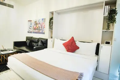 a bedroom with a large white bed and a couch at Luxury Studio Bayz By Danube Business Bay Marasi Drive Dubai in Dubai