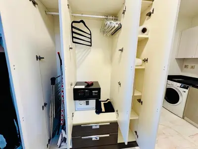 a walk in closet with a staircase and a washer and dryer at Luxury Studio Bayz By Danube Business Bay Marasi Drive Dubai in Dubai