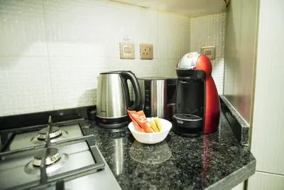 a kitchen counter with a stove and a coffee maker at Luxury Studio Bayz By Danube Business Bay Marasi Drive Dubai in Dubai