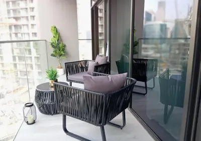 a balcony with three chairs and a table on a building at Bespoke Holiday Homes - Luxury 1BR in High Floor with Stunning Canal Views in Dubai