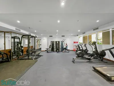 a gym with lots of treadmills and cardio machines at Serene 1 Bedroom apartment in Belgravia - JVC in Dubai