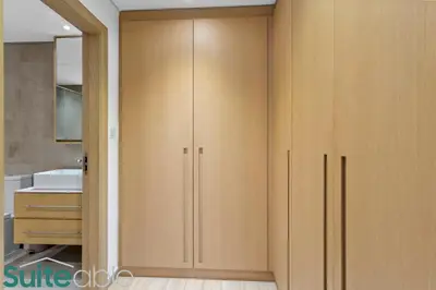 a closet with wooden doors in a bathroom at Serene 1 Bedroom apartment in Belgravia - JVC in Dubai