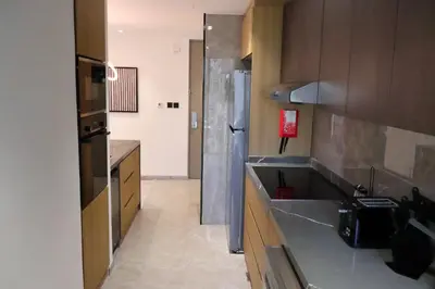 a kitchen with a sink and a refrigerator at JW Marriott Stylish 1BR - Marina View - Direct Dubai Marina Mall Access - Pool & Gym - Free Parking in Dubai