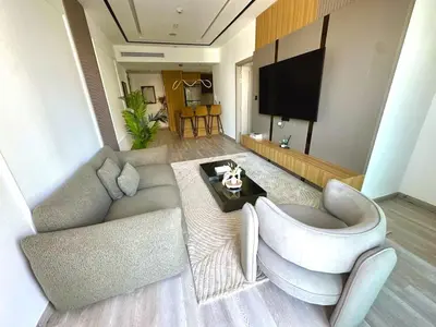 a living room with a couch and a tv at JW Marriott Stylish 1BR - Marina View - Direct Dubai Marina Mall Access - Pool & Gym - Free Parking in Dubai