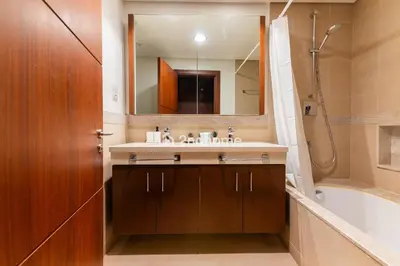 a bathroom with a sink and a mirror and a tub at Burj Vista Tower 2, Downtown - Upgarded 2 bedroom in Dubai