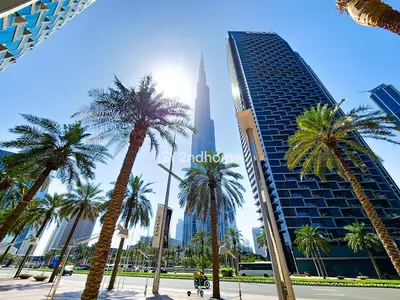 a group of palm trees in front of a tall building at Burj Vista Tower 2, Downtown - Upgarded 2 bedroom in Dubai