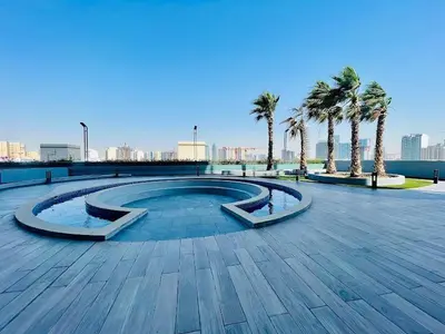 a swimming pool with palm trees in a park at Fully Furnished Cozy Studio at JVC Dubai, Short Drive to Dubai Marina, JBR, Downtown Dubai in Dubai