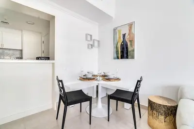 a white dining room with a white table and chairs at GuestReady - Glamorous stay in Dubai Marina in Dubai