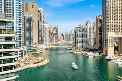 a river with boats in a city with tall buildings at GuestReady - Glamorous stay in Dubai Marina in Dubai