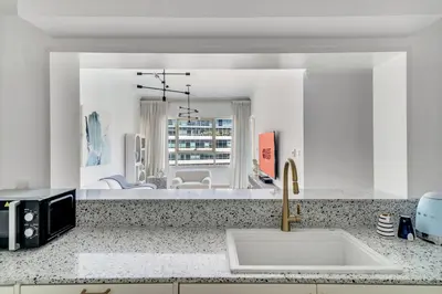 a kitchen with a sink and a living room at GuestReady - Glamorous stay in Dubai Marina in Dubai