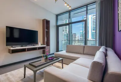 a living room with a couch and a large window at MBL Royal, JLT- 1-BR Apartment with Lake View in Dubai