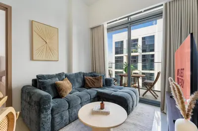 a living room with a blue couch and a table at GuestReady - Contemporary retreat at Azizi Gardens in Dubai