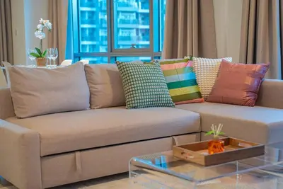 a living room with a couch with colorful pillows at Luxury Living Brand New 1 Bed Downtown Dubai Southridge in Dubai
