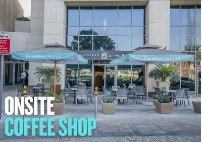 an outside coffee shop with tables and chairs and umbrellas at Luxury Living Brand New 1 Bed Downtown Dubai Southridge in Dubai