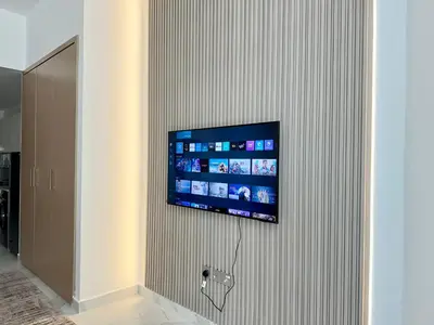 a flat screen tv hanging on a wall at Millenium Binghatti Residences Business Bay- Stylish Studio with Canal View in Dubai