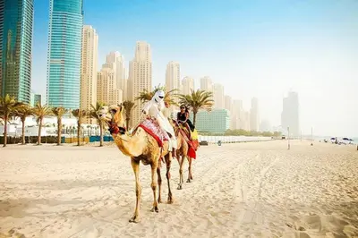 two people riding on camels on a beach with a city at ONE Bedroom with Sea view in Dubai Marina - Z1106 in Dubai