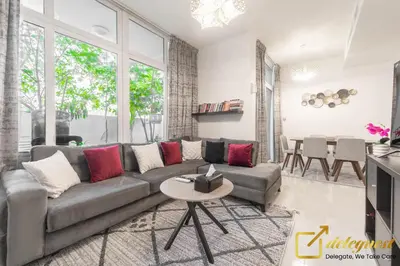 a living room with a couch and a table at Tranquil 3br Townhouse in Damac Hills2 by deleguest in Dubai
