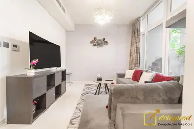 a living room with a television and a couch at Tranquil 3br Townhouse in Damac Hills2 by deleguest in Dubai
