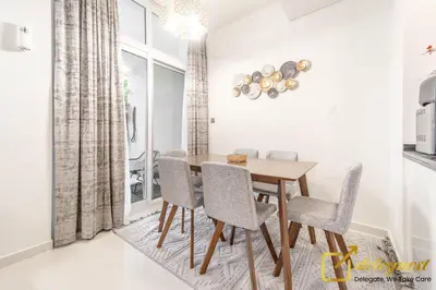 a dining room with a wooden table and chairs at Tranquil 3br Townhouse in Damac Hills2 by deleguest in Dubai