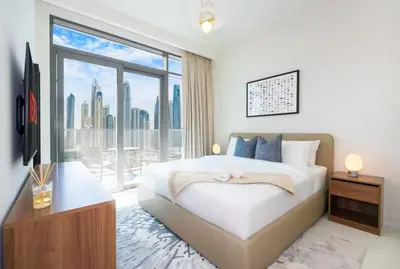 a bedroom with a bed and a large window at شقة مع منظر رائع in Dubai