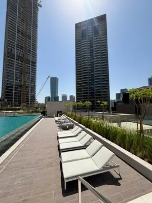 a row of white lounge chairs next to a pool at Sky Burj Khalifa View in Dubai