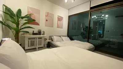 a bedroom with two beds and a potted plant at Sky Burj Khalifa View in Dubai