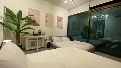 a bedroom with two beds and a potted plant at Sky Burj Khalifa View in Dubai