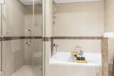 a bathroom with a shower and a sink and a tub at Lux Burj and Fountain views Steps from Dubai Mall in Dubai
