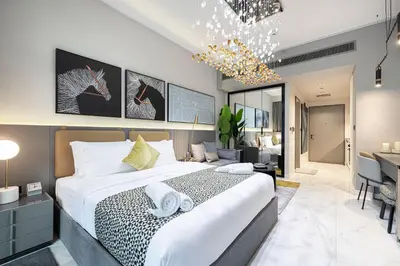 a bedroom with a large bed and a desk at Chic Studio 5 Min Walk to Dubai Mall & Burj in Dubai