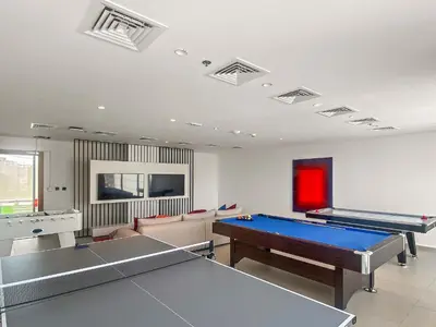 a living room with two ping pong tables at Modern Studio in Al Furjan with pool and gym in Dubai