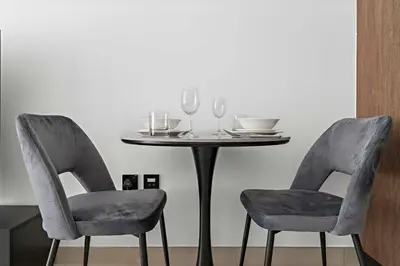 a table with two chairs and a table with wine glasses at Modern Studio in Al Furjan with pool and gym in Dubai