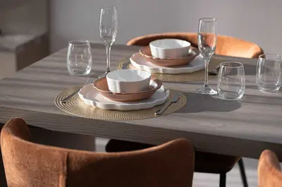 a table with two plates and wine glasses on it at Modern 1-Bedroom Apartment with Luxurious Amenities in JVC in Dubai