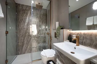 a bathroom with a toilet and a sink and a shower at Modern 1-Bedroom Apartment with Luxurious Amenities in JVC in Dubai
