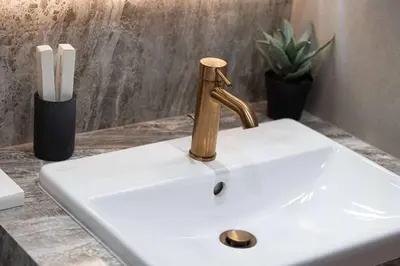 a sink with a brass faucet on a counter at Modern 1-Bedroom Apartment with Luxurious Amenities in JVC in Dubai