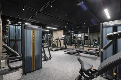 a gym with several treadmills and machines in it at Modern 1-Bedroom Apartment with Luxurious Amenities in JVC in Dubai