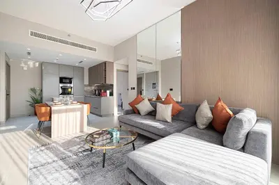 a living room with a couch and a table at Modern 1-Bedroom Apartment with Luxurious Amenities in JVC in Dubai