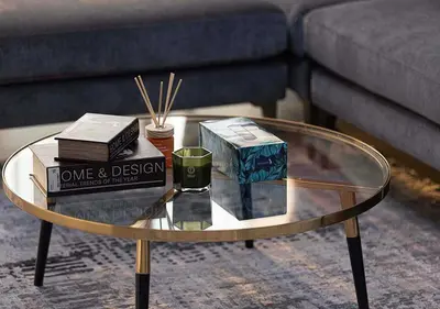 a glass coffee table with books and candles on it at Chic 1-Bed Apartment with Exclusive Amenities JVC in Dubai