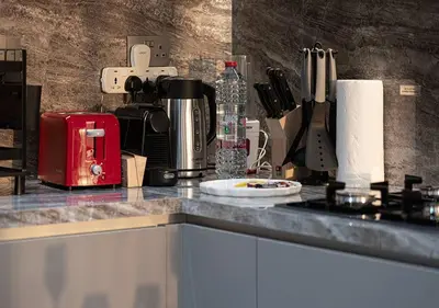 a kitchen counter top with a coffee maker and appliances at Chic 1-Bed Apartment with Exclusive Amenities JVC in Dubai