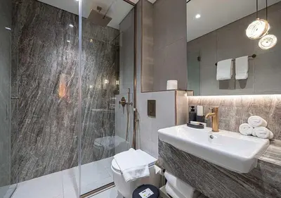 a bathroom with a sink and a shower at Chic 1-Bed Apartment with Exclusive Amenities JVC in Dubai