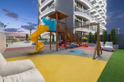 a playground in front of a building with a slide at Chic 1-Bed Apartment with Exclusive Amenities JVC in Dubai