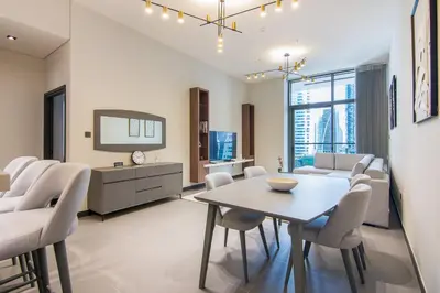 a living room with a table and chairs at MBL Royal, JLT- Two Bedroom with Lake View in Dubai