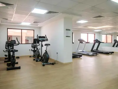 a gym with several treadmills and exercise bikes at Modern Studio Retreat in Sports City Dubai in Dubai