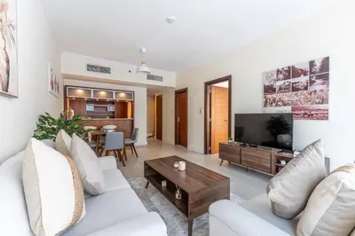 a living room with a white couch and a tv at HAVN - 1 Bed in Dubai Marina, 5mins walk to JBR in Dubai