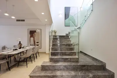 a staircase in a dining room with a table and chairs at Livbnb-Tranquil Family Home, 4BR with Maid's Room in Dubai