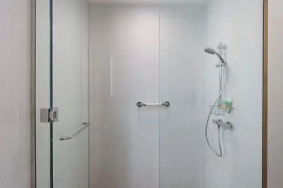 a shower with a glass door next to a shower at Livbnb-Tranquil Family Home, 4BR with Maid's Room in Dubai