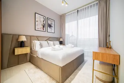 a bedroom with a large bed and a window at SettlerHomes - Chic JVC Cityview Near Heart of Dubai in Dubai