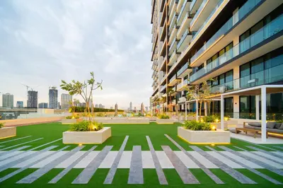 a courtyard in a building with grass and plants at SettlerHomes - Chic JVC Cityview Near Heart of Dubai in Dubai