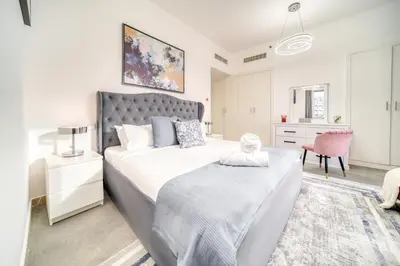 a bedroom with a large bed and a pink chair at THE JBR Grand Luxury Sea View 4 BEDROOM in Dubai